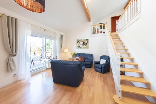 a living room with a staircase and a couch at Parkhotel an der Therme in Bad Krozingen