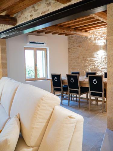 un salon avec un canapé, une table et des chaises dans l'établissement Maison PALOMA, Maison de charme à deux pas du Pont du Gard, à Castillon-du-Gard