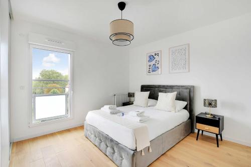 une chambre blanche avec un grand lit et une fenêtre dans l'établissement Chic Duplex with Rooftop -3BD-6P- Nogent-sur-Marne, à Nogent-sur-Marne
