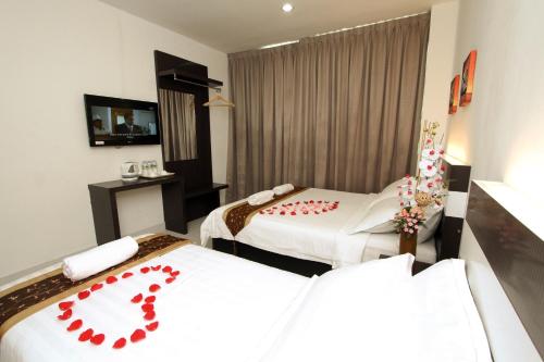 a hotel room with two beds with red hearts on them at New Century Hotel Melaka in Melaka