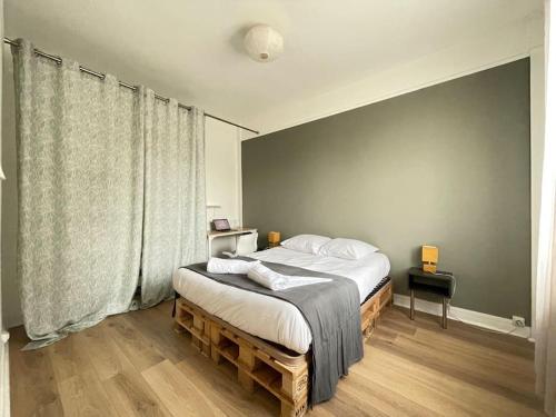 une chambre avec un lit et une grande fenêtre dans l'établissement Rouen Gare - Les Marronniers, à Rouen