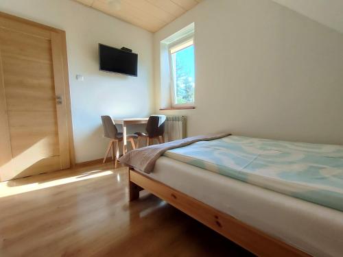 a bedroom with a bed and a table with chairs at Pokoje gościnne Zawoja Centrum Henryk Hadka in Zawoja