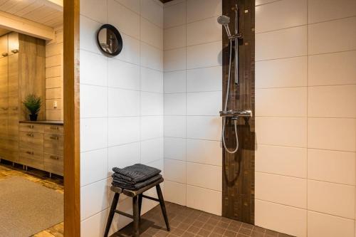 a shower stall with a stool in a bathroom at Kurjenkenkä by HiYlläs in Kittilä