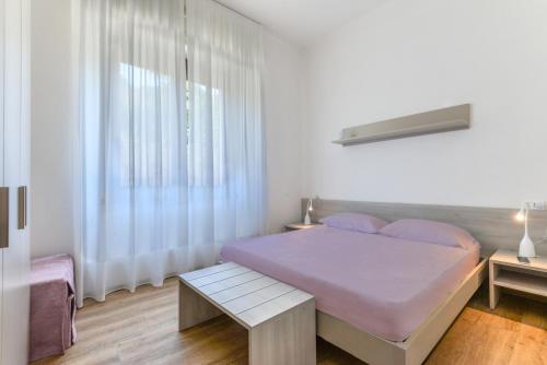 una camera da letto bianca con un letto e una finestra di Casette del Pescatore - HelloElba a Portoferraio