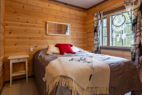 a bedroom with a bed in a log cabin at Kurjenkenkä by HiYlläs in Kittilä