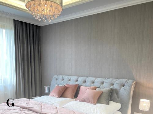 a bedroom with a bed with pink and white pillows at Apartmány GRENT Donovaly in Donovaly