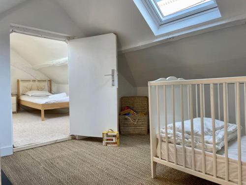 1 dormitorio con cuna y tragaluz en Rouen Gare - le Cabanon Grand Large, en Rouen
