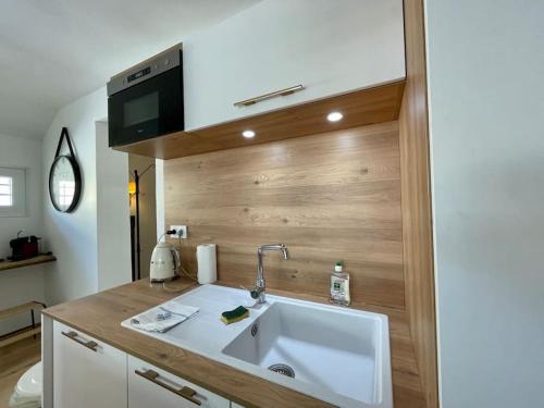Una cocina con fregadero y una pared de madera. en Rouen Gare - le Cabanon Grand Large, en Rouen