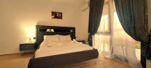 a bedroom with a bed and a large window at Villa Gio Kvareli in Kvareli