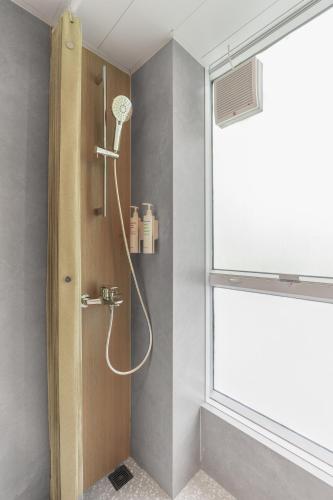 a shower in a bathroom with a window at Urbanwood Hung Hom in Hong Kong