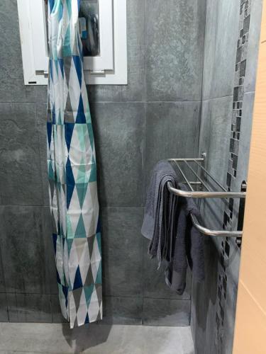 a shower in a bathroom with a shower curtain at appartement pour vacances avec piscine in Bouznika