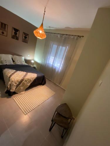 a bedroom with a bed and a lamp and a chair at appartement pour vacances avec piscine in Bouznika