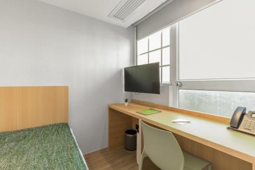 an office with a desk with a computer and a phone at Urbanwood Hung Hom in Hong Kong