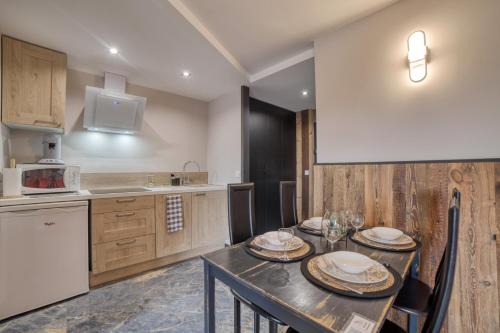 a kitchen with a table with plates and bowls on it at Charmant appartement avec balcon et commodités modernes in Samoëns