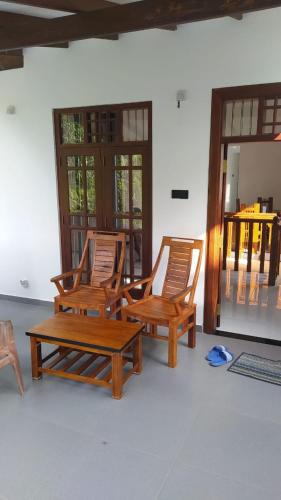 two wooden chairs and a table in a room at Villa 142 in Weligama