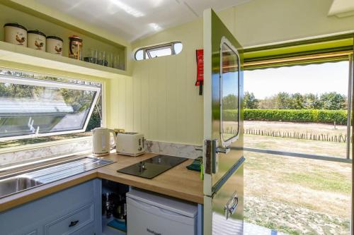a kitchen with a sink and a window at The Showman's Carriage w King Bed close to beach in Birdham