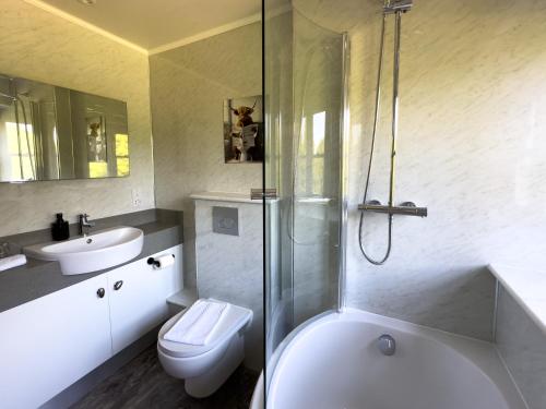 a bathroom with a shower and a toilet and a sink at Dunningwell Hall in Duddon