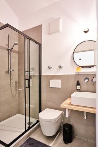 a bathroom with a shower and a toilet and a sink at Alte Seifensiederei - Astrid in Bad Tölz