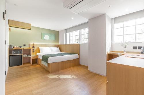 a small bedroom with a bed and a kitchen at Urbanwood Hung Hom in Hong Kong