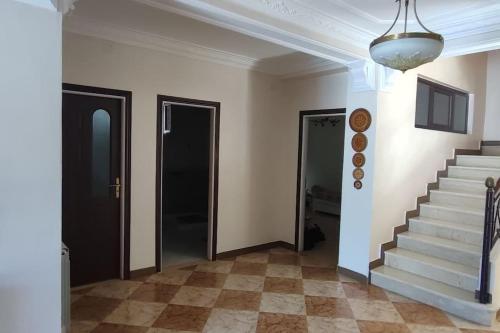 a hallway with a staircase and a door and a ceiling at Dar El Salha in Zeralda