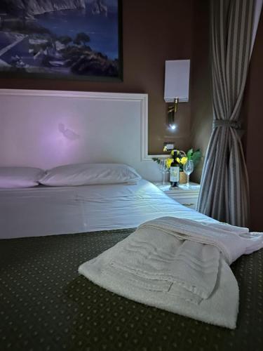 a bed with a white blanket laying on it at Cervara Park Hotel in Rome