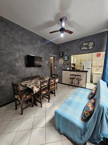 a living room with a dining room table and a kitchen at CABO FRIO - Praia do Forte lindo e aconchegante in Cabo Frio