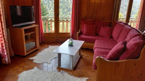 a living room with a couch and a tv at Chalet Les Rennes REN MOUNTAIN & NATURE 10 Pers in Châtel
