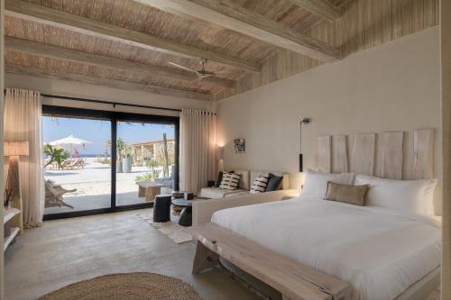 a bedroom with a large bed and a patio at Marmarica Boutique Cabanas - Ras El Hekma - North Coast Top Rated Luxury Stay in Marsa Matruh