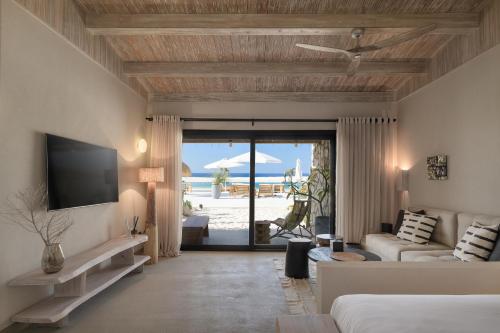 a living room with a couch and a tv and a patio at Marmarica Boutique Cabanas - Ras El Hekma - North Coast Top Rated Luxury Stay in Marsa Matruh