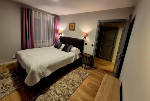 a bedroom with a large bed and a door at Butas Ežero 30 in Plateliai
