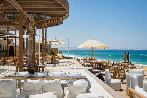 a restaurant on the beach with tables and chairs at Marmarica Boutique Cabanas - Ras El Hekma - North Coast Top Rated Luxury Stay in Marsa Matruh