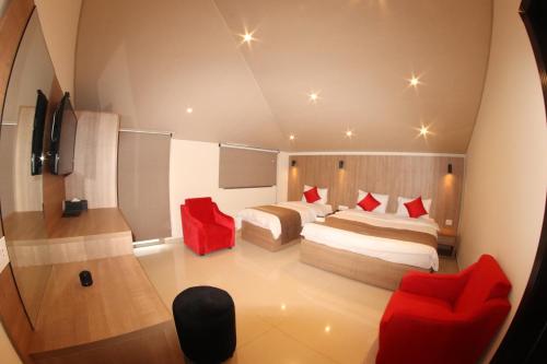 a hotel room with two beds and red chairs at Jounieh Suites Boutique Hotel in Jounieh