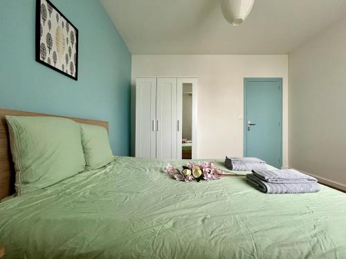 - un lit avec un bouquet de fleurs dans l'établissement Grand Appartement à Deux Pas De La Vieille Ville, à Vannes