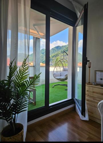 a room with a sliding glass door with a plant at La Casina Del Alce in Aller