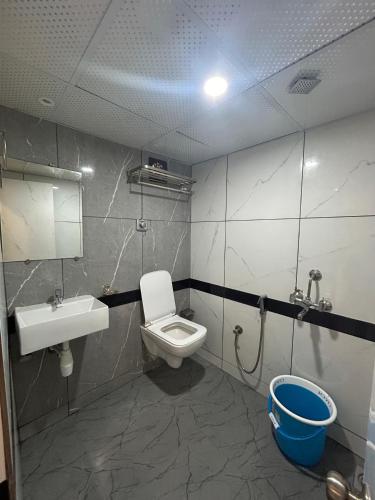 a bathroom with a toilet and a sink at Hotel Rinza Residency in Mumbai