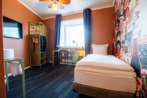 a small room with a bed and a desk at Hotel Hafnia in Tórshavn