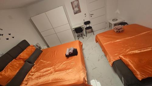 two beds in a room with orange sheets at ENA 1&2 -BIG FREE PRIVAT parking for BOATS, TRUCKs, combi,-CENTRAL HEATING !!! in Karlovac