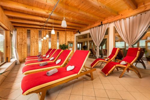a row of red chairs in a room at Alpen Wohlfühlhotel Dörflwirt in Hainzenberg