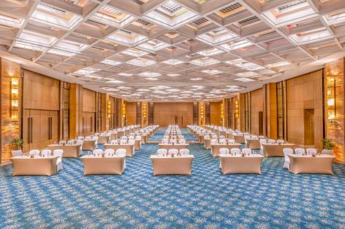 a large room with rows of tables and chairs at The Leela Ambience Convention Hotel Delhi in New Delhi