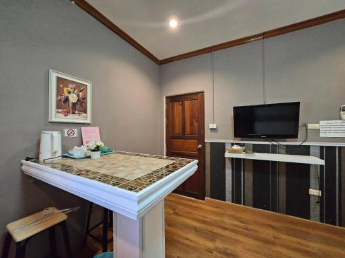a room with a bar with a tv and a table at Guesthouse Phuket Airport in Ban Bo Han