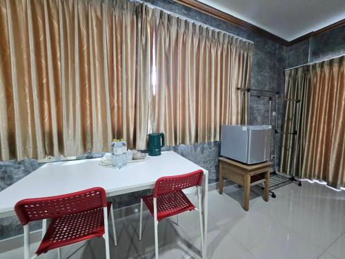a room with a table and two chairs and a tv at Guesthouse Phuket Airport in Ban Bo Han