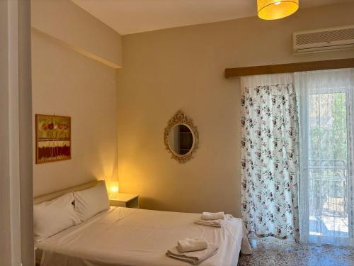 a bedroom with a bed and a window at Galazia Nera Apartments in Áyios Andréas Messinias