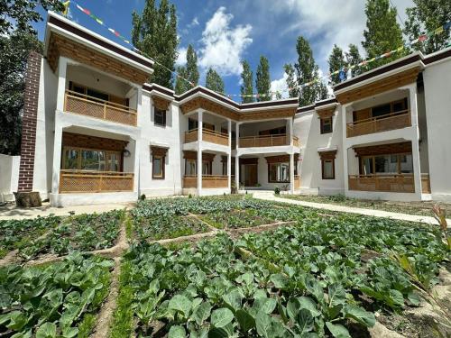 a vegetable garden in front of a building at Losar Guest House Ladakh by LexStays in Leh