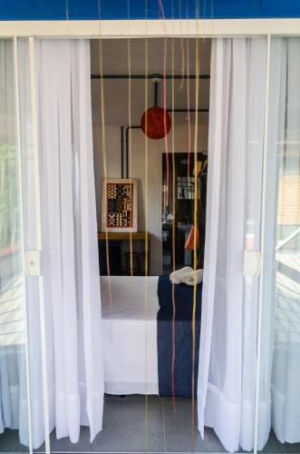 a window with white curtains in a room at Alma Brava in Itajaí