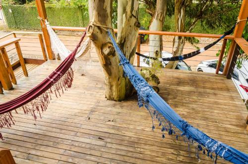 a hammock on a wooden deck with a tree at Alma Brava in Itajaí