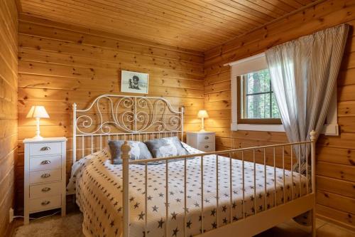 a bedroom with a bed in a log cabin at Rovankoto by Hi Ylläs in Ylläsjärvi