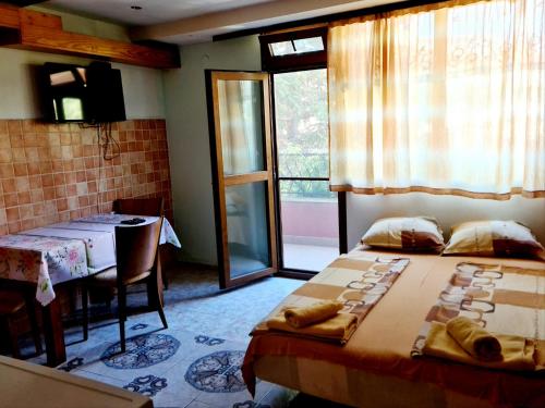 a room with two beds and a table and a window at Цар Калоян in Primorsko