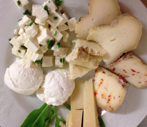 a plate of food with cheese and other vegetables at Cascina Bosco Gerolo in Rivergaro