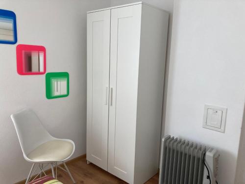 armadio bianco in una stanza con sedia di Garden apartment a Karlovo