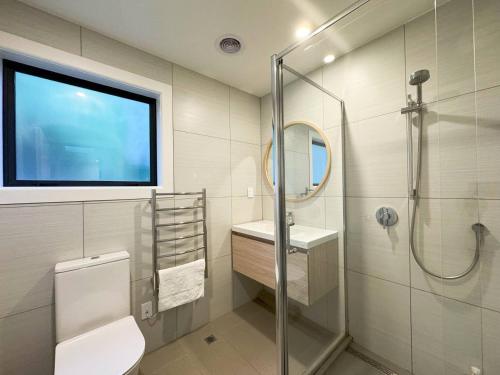 a bathroom with a shower and a toilet and a sink at NO PARTY ALLOWED, Entire Brand New 3 bedroom townhouse, free unlimited fibre wifi and free parking in Wellington
